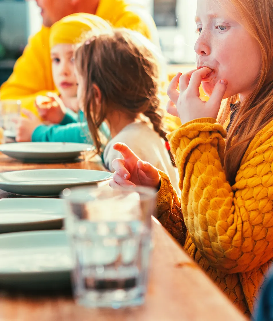 Kinderen eten samen aan tafel bij kinderopvang Kind&co ludens